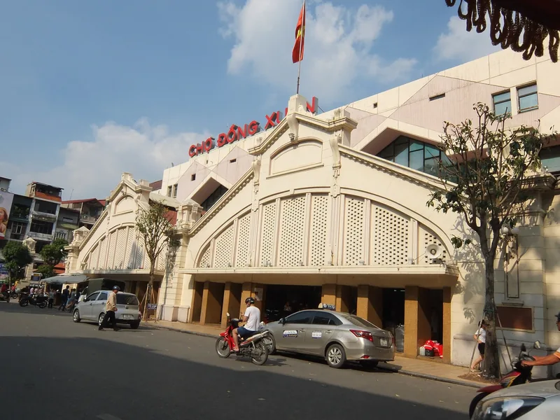 Mặt tiền vòm của chợ Đồng Xuân với xe cộ qua lại trên phố khu Phố Cổ Hà Nội.